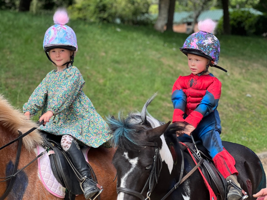 Children in colourful outfits enjoying pony rides at The Unicorn